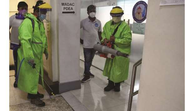 Workers wearing protective equipment disinfect an office as a preventative measure against the Covid-19 coronavirus at the city hall in Manila, yesterday.