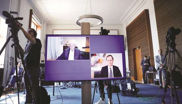 CureVac main shareholder Dietmar Hopp and Acting CEO Franz-Werner are displayed on a screen during a news conference with German Economy Minister Peter Altmaier at the Economic Ministry in Berlin yesterday.