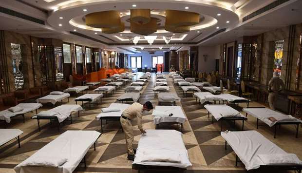 A civil defence volunteer prepares a bed at a banquet hall temporarily converted into isolation ward for Covid-19 coronavirus patients in New Delhi yesterday.