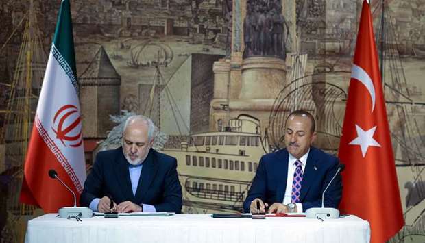 This handout picture released yesterday shows Turkish Foreign Minister Mevlut Cavusoglu and Iranian Foreign Minister Mohamed Javad Zarif attend a signing ceremony and press conference after their meeting at the Dolmabahce Palace Presidential Work Office in Istanbul.