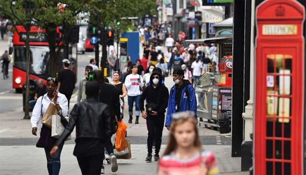 Shoppers walk a a busy Oxford Street in London as some non-essential retailers reopen from their coronavirus shutdown