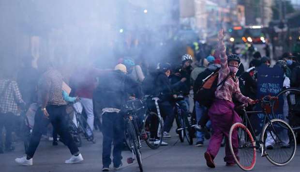 Demonstrators flee tear gas launched by riot police during a protest among a series of ongoing demonstrations calling for dignified life, amidst an outbreak of the coronavirus, in Bogota, Colombia.