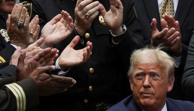US President Donald Trump listens to applause after signing an executive order on police reform during a ceremony in the Rose Garden at the White House in Washington