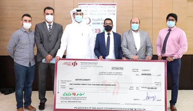 Officials of Qatar Charity and LuLu Hypermarket Qatar at the cheque-handing over ceremony.