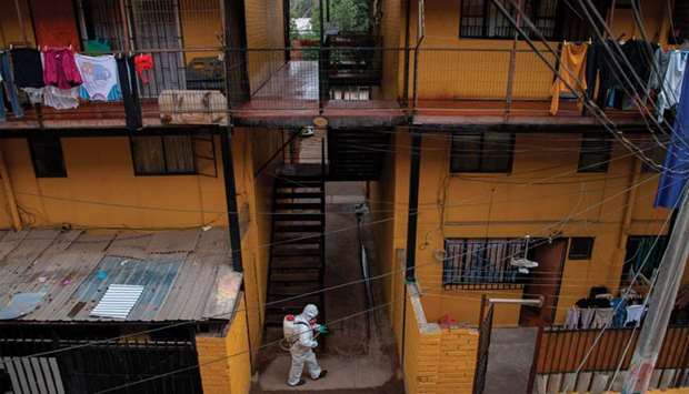 A municipal worker cleans and disinfects a low-income commune in Santiago amid the new coronavirus pandemic.
