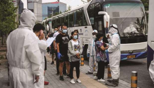 People who had their car number plates recorded in the area of the Xinfadi market where a new coronavirus cluster emerged last week, wait to do swab tests for the coronavirus after being transported with buses to a testing centre in Beijing yesterday.