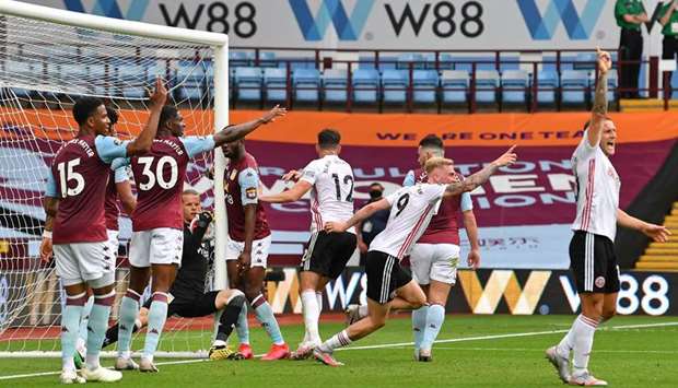 Aston Villau2019s goalkeeper Orjan Nyland (third from left) falls back into the goal holding the ball as the Sheffield United players celebrate a goal which wasnu2019t awarded during the EPL match yesterday. (AFP)