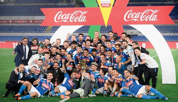 Napoliu2019s players and staff celebrate with the trophy after winning the Italian Cup at the Olympic stadium in Rome on Wednesday night. (AFP)