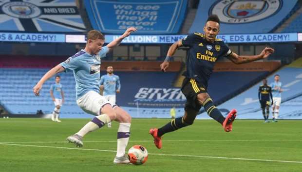 Manchester Cityu2019s midfielder Kevin De Bruyne (left) and Arsenalu2019s striker Pierre-Emerick Aubameyang vie for the ball during the English Premier League match at the Etihad Stadium in Manchester, on Wednesday night. (AFP)