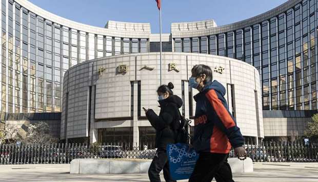 Pedestrians wearing protective masks walk past the Peopleu2019s Bank of China building in Beijing. u201cThe PBoC needs to start using some policies to guide market expectations and to show investors that the easing cycle will be in place for the coming six months,u201d said Larry Hu, head of China economics at Macquarie Securities.