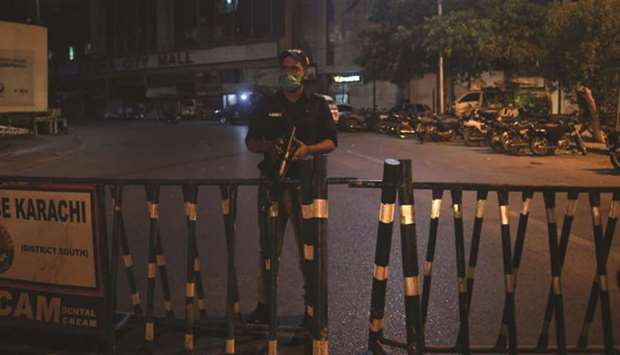 A police officer stands guard on a street sealed by the authorities at a residential area in Karachi.