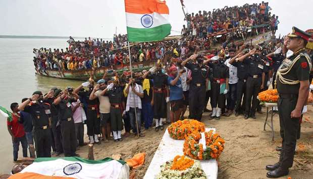 An officer pays tribute to Sunil Kumar, a soldier who was martyred in a border clash with Chinese troops in Ladakh region, during the funeral service in Maner, Bihar.
