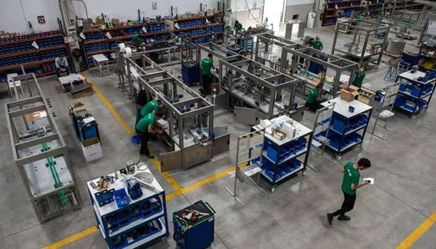 Employees work on a machine that makes masks at the AND & OR factory in Sevilla . The AND & OR group has launched a machine capable of producing 1 million masks per week.