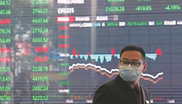 A man wearing a protective mask is seen inside the Shanghai Stock Exchange building. The Composite index closed up 1.0% to 2,967.63 points yesterday.