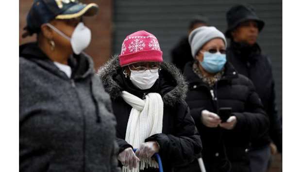 FILE PHOTO: People wearing protective masks wait in line for donated food distribution at the Queensbridge Houses, a New York City Housing Authority (NYCHA) public housing complex, during the outbreak of the coronavirus disease (Covid-19) in the Queens borough of New York, US, on April 21.