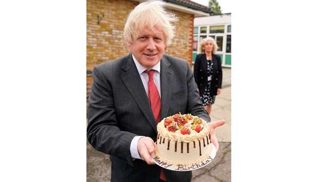 Prime Minister Boris Johnson holds a birthday cake presented to him by the staff during a socially distanced visit to Bovingdon Primary School in Bovingdon, Hemel Hempstead, Hertfordshire, yesterday.