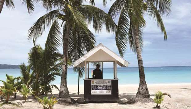 This photo shows a policeman standing guard along the empty famous white beach of Boracay Island in central Philippines, as community quarantine against Covid-19 still continues, with foreign tourists still banned on beaches.