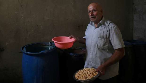 Marwan Kuwaik, a 70-year-old Palestinian among the 1.4mn people listed by the UN as registered refugees in Gaza, prepares lupin beans to sell them, in his house in Gaza City.