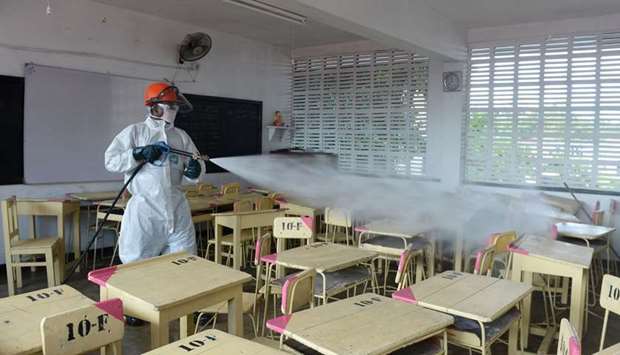 A health worker sprays disinfectant in a classroom at the Anula school, in the suburb of Nugegoda in Colombo yesterday. Sri Lanka has been steadily lifting lockdown restrictions,  although a night-time curfew remains. Schools will reopen later this month and foreign tourists will be allowed from August 1.