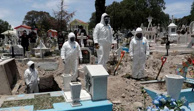 Cemetery workers wearing protective suits complete the burial of a man, who died of the coronavirus disease (COVID-19), at San Efren Municipal Cemetery, as the coronavirus disease outbreak continues, in Ecatepec de Morelos, on the outskirts of Mexico City