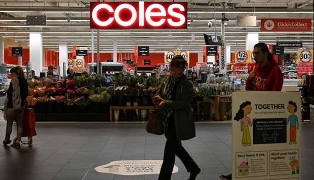 People walk past a Coles supermarket following the easing of restrictions implemented to curb the spread of the coronavirus disease in Sydney, Australia