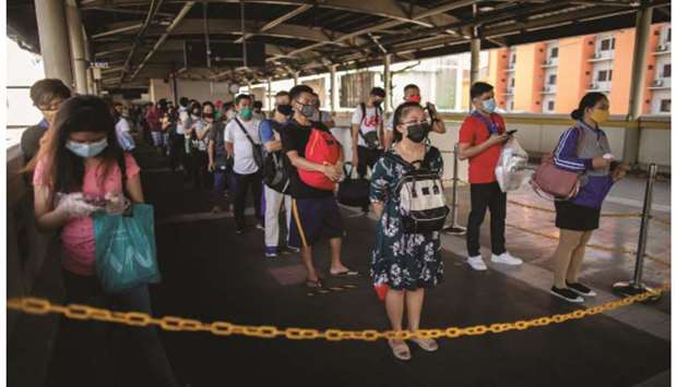 Passengers queue to go to the train platform as social distancing is strictly implemented on the trains on its first day of reopening since the lockdown to contain the coronavirus disease (Covid-19) over two months ago, in Manila, yesterday.