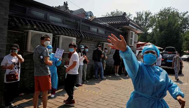 A nurse in a personal protective equipment (PPE) gestures at the photographer outside a makeshift testing site, after a new outbreak of the coronavirus disease in Beijing.