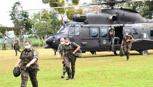 Members of the medical team of the Brazilian Armed Forces disembark from a helicopter in Atalaia do Norte, Amazonas state, northern Brazil, on the border with Peru, amid the Covid-19 pandemic