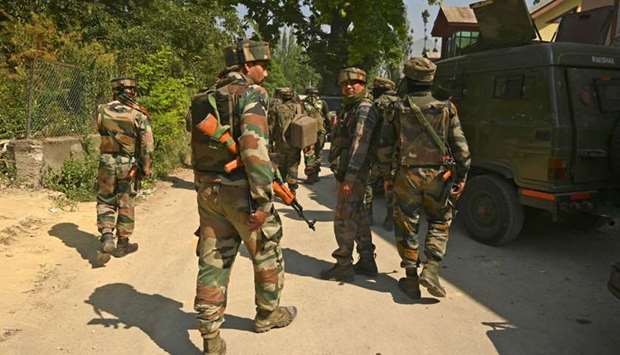 Indian army soldiers leave near a mosque at the site of a gunbattle at Meej Pampore area of Pulwama district, south of Srinagar on June 19.