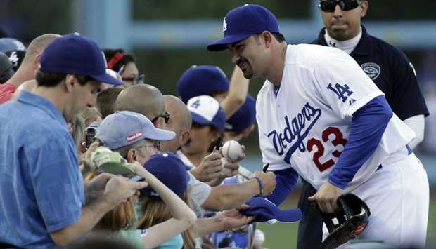 Los Angeles Dodgersu2019 Adrian Gonzalez signs baseball for fans before a game on August 25, 2012. (TNS)