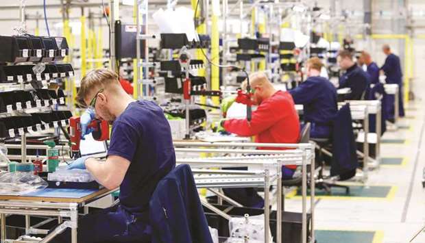 Employees work on the absorber component of a ventilator on the production line in an adapted hangar at the Airbus assembly plant in Broughton, UK. The European plane maker will mandate redundancies only as a last resort after looking at voluntary layoffs and early retirement across its manufacturing operations, sources said.