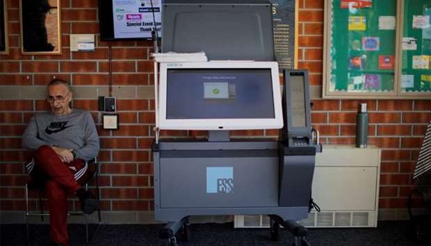 Elections official Bernie Ou2019Hare waits to help voters use a new Election Systems & Software ExpressVote XL voting machine