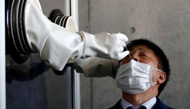 A medical worker conducts a simulation for a walk-in style polymerase chain reaction (PCR) test for the coronavirus disease, at a makeshift facility in Yokosuka, south of Tokyo, Japan