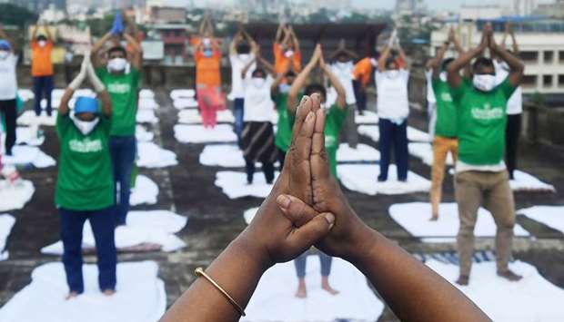 Health workers and staff of Jitendra Narayan Roy hospital perform yoga postures on the terrace of the hospital building to celebrate the International Yoga Day in Kolkata yesterday.