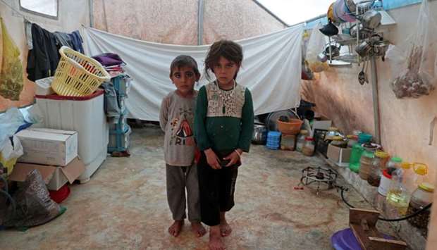 Jumana and Farhan al-Alyawi, a 8-year-old displaced Syrian twins from east Idlib, pose for a picture in a tent at Atmeh camp, near the Turkish border, Syria on June 19