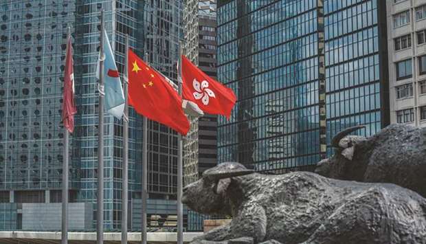 The flag of the Hong Kong Special Administrative Region (right), flies alongside the flag of China outside the Exchange Square complex, which houses the Hong Kong Stock Exchange. The Hang Seng index rallied 1.1% to 23,995.94 points yesterday.