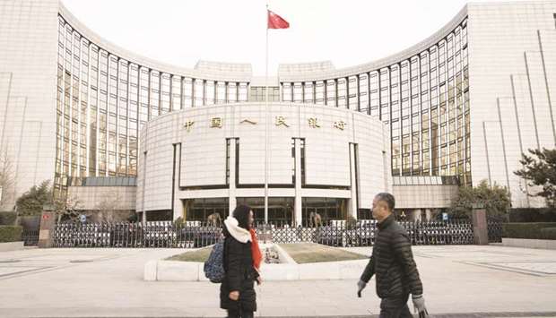 Pedestrians walk past the Peopleu2019s Bank of China headquarters in Beijing. The central bank will sign contracts with qualified local commercial lenders via a special-purpose vehicle, and the plan could boost banksu2019 unsecured loans to small firms by 1tn yuan, it said yesterday.