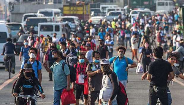 Commuters returning to work are stranded along Commonwealth Avenue in Quezon City in Metro Manila, due to lack of sufficient buses to head to various locations.