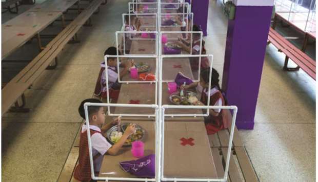Kindergarten students from the Wichuthit School eat their lunch during a rehearsal social distancing and measures to prevent the spread of the coronavirus disease (Cocid-19) ahead of nationwide schools reopening in Bangkok yesterday.