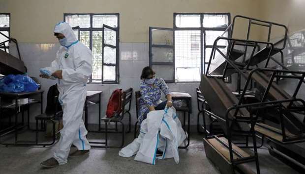 Medical health workers put on Personal Protective Equipment (PPE) as they get ready to work at a school that was turned into a centre for conducting tests for the coronavirus disease in New Delhi yesterday.