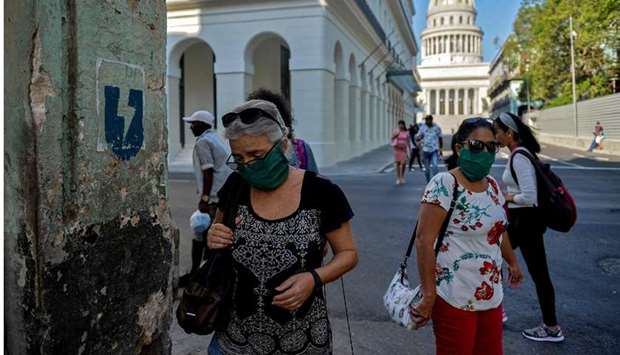 Women wearing face masks walk along a street of Havana yesterday amid the new coronavirus pandemic. Cuba yesterday reported only one new confirmed case of Covid-19.