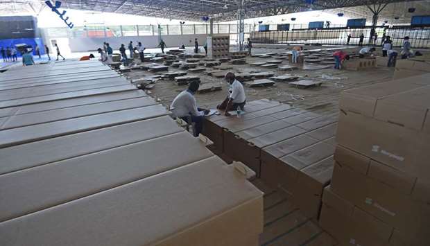 Workers make cardboard beds inside the campus hall of Radha Soami Satsang Beas (RSSB), a spiritual organisation, which is being converted into a 10,000-bed Covid-19 care centre, in New Delhi yesterday.