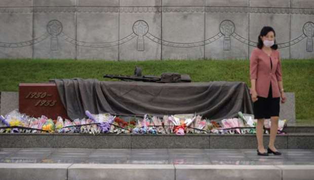 A woman stands before flowers and a monument at the Fatherland Liberation War Martyrs Cemetery in Pyongyang yesterday.