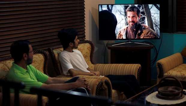 Family members watch an Urdu dubbed version of Turkish TV series Dirilis: Ertugrul on a television screen at home in Karachi yesterday.