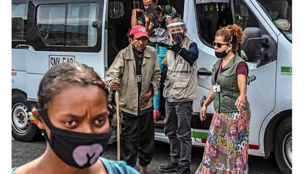 Homeless people get off a van transporting them to an area provided for them to take a shower and eat amid the Covid-19 pandemic in Medellin, Colombia.