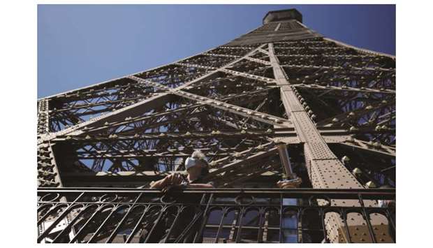 A visitor admires the view from the Eiffel Tower during its partial reopening. Tourists and Parisians will again be able to admire the view of the French capital from the Eiffel Tower after a three-month closure due to the coronavirus, but only if they take the stairs.