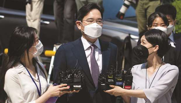 Jay Y Lee, co-vice chairman of Samsung Electronics (centre), wears a protective mask as he is surrounded by members of the media while arriving at the Central District Court in Seoul. Lee was jailed for about a year, until his release in February 2018, for his role in a bribery scandal.