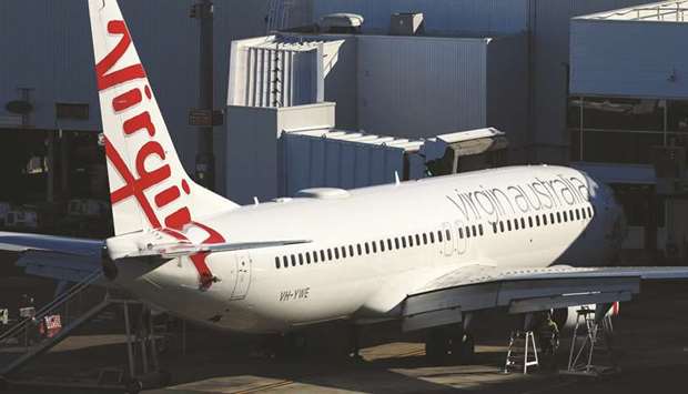 An aircraft operated by Virgin Australia Holdings stands at a gate at Sydney Airport. Bain Capital agreed to buy collapsed airline Virgin Australia in one of the biggest single bets on the industry since it was shattered by the coronavirus pandemic.