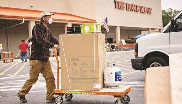 A customer wears a protective mask while pushing a cart outside a Home Depot store in Reston, Virginia. The Commerce Department said consumer spending, which accounts for more than two-thirds of US economic activity, jumped 8.2% last month.