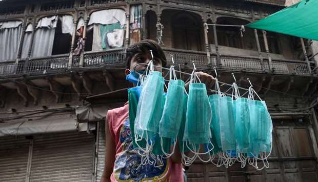 A young vendor is seen selling facemasks on a Lahore street near an area sealed by the authorities because of the spread of the coronavirus.